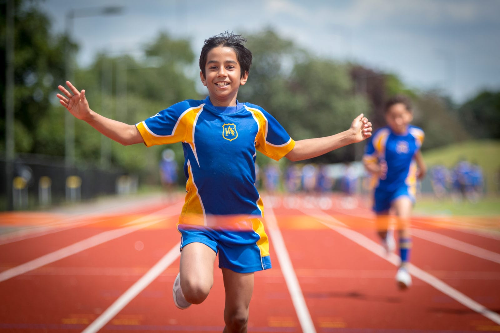 Image of a pupil in sports wear approaching the finishing live on a race track - www.ashtonhouse.com